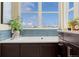 Bright bathroom featuring a soaking tub with blue tile and a large window offering a scenic view at 10826 Evergold Way, Highlands Ranch, CO 80126