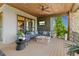 Relaxing covered deck with a stone fireplace and comfortable seating, ideal for outdoor enjoyment at 10826 Evergold Way, Highlands Ranch, CO 80126