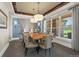 Elegant dining room featuring a stone accent wall, designer lighting, and a large window at 10826 Evergold Way, Highlands Ranch, CO 80126