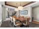 Formal dining room with a large wood table, modern lighting, and stairs in the background at 10826 Evergold Way, Highlands Ranch, CO 80126