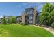 Lush green lawn surrounding modern home with stone accents and large windows at 10826 Evergold Way, Highlands Ranch, CO 80126