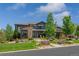 Stunning home featuring a stone and siding exterior, beautifully landscaped yard, and well-maintained lawn at 10826 Evergold Way, Highlands Ranch, CO 80126