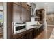 Gourmet kitchen features stainless steel appliances, rich dark cabinetry, and a sleek range hood at 10826 Evergold Way, Highlands Ranch, CO 80126