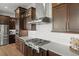 Modern kitchen featuring a gas range, stainless steel appliances, white subway tile, and dark cabinetry at 10826 Evergold Way, Highlands Ranch, CO 80126