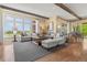 Bright and airy living room with comfortable seating, a large rug, and expansive windows overlooking the landscape at 10826 Evergold Way, Highlands Ranch, CO 80126