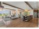 Open-concept living room and kitchen featuring hardwood floors, large windows, and stylish decor at 10826 Evergold Way, Highlands Ranch, CO 80126
