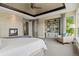 Well-lit bedroom with a fireplace, built-in shelving, and comfortable chair near the window at 10826 Evergold Way, Highlands Ranch, CO 80126