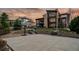 A basketball court sits at the edge of a modern home with multi-story windows and a stone facade and chimney at 10826 Evergold Way, Highlands Ranch, CO 80126