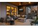 An outdoor seating area on a covered deck features a stone fire pit, sectional sofa and outdoor TV at 10826 Evergold Way, Highlands Ranch, CO 80126