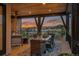 A covered deck has a dining table and chairs set on a patterned rug with sunset views at 10826 Evergold Way, Highlands Ranch, CO 80126