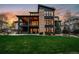Back exterior view of the home features a spacious lawn, stone accents, and a deck at 10826 Evergold Way, Highlands Ranch, CO 80126
