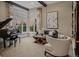 Bright living room with large windows, a piano, and comfortable seating arrangements at 10826 Evergold Way, Highlands Ranch, CO 80126