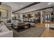 Open concept living room and kitchen with exposed beams, hardwood floors, and island with seating at 10826 Evergold Way, Highlands Ranch, CO 80126