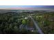 Aerial view showcasing a neighborhood with houses surrounded by lush trees and city lights in the background at 21859 Grandview Ave, Golden, CO 80401