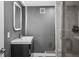Modern bathroom featuring a gray vanity, a lighted mirror, and a sleek, glass-enclosed shower at 21859 Grandview Ave, Golden, CO 80401
