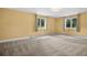 Bright bedroom featuring neutral carpeting, yellow walls, and windows that bring in natural light at 21859 Grandview Ave, Golden, CO 80401