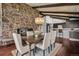 Charming dining room featuring a stone fireplace, hardwood floors, and elegant chandelier at 21859 Grandview Ave, Golden, CO 80401