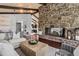 Open-concept living area with stone fireplace, wood beams, and hardwood floors at 21859 Grandview Ave, Golden, CO 80401