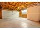Interior of a spacious two car garage featuring bare walls and an exposed beam ceiling at 901 Delphi Dr, Lafayette, CO 80026