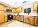 Bright kitchen featuring wooden cabinets, modern appliances, white countertops, and a window at 901 Delphi Dr, Lafayette, CO 80026