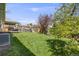 Lush backyard with green grass, mature trees, and a deck for outdoor entertaining at 13367 W Montana Pl, Lakewood, CO 80228