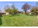 Expansive backyard with a well-maintained lawn, playground, and covered patio area at 13367 W Montana Pl, Lakewood, CO 80228