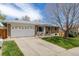 Charming ranch-style home featuring a well-manicured lawn, brick accents, and an attached two-car garage at 13367 W Montana Pl, Lakewood, CO 80228