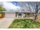 Charming ranch-style home featuring a well-manicured lawn, brick accents, and an attached two-car garage at 13367 W Montana Pl, Lakewood, CO 80228