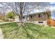 Landscaped front yard of a ranch-style home with brick exterior, mature trees, and a two-car garage at 13367 W Montana Pl, Lakewood, CO 80228