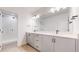 Modern bathroom featuring double sinks, vanity, contemporary fixtures, and a glass-enclosed shower at 885 Delechant Dr, Erie, CO 80516