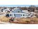 Charming two-story blue home with a welcoming front porch, lush landscaping, and a fenced yard at 885 Delechant Dr, Erie, CO 80516