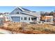 Charming two-story home with blue siding, white trim, a cozy front porch, and solar panels on the roof at 885 Delechant Dr, Erie, CO 80516