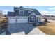 Charming craftsman-style home with a three-car garage, a well-manicured lawn, and covered porch at 885 Delechant Dr, Erie, CO 80516