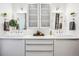 Elegant bathroom with double sinks, sleek white cabinetry, modern lighting fixtures, and decorative plants and towels at 3039 N Milwaukee St, Denver, CO 80205