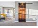 Bright hallway features a dark wood sliding barn door and a glimpse of a sitting area with a cozy armchair at 3039 N Milwaukee St, Denver, CO 80205