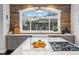 Bright kitchen featuring an island with a cooktop, gray cabinets, quartz counters, and wood-paneled backsplash at 3039 N Milwaukee St, Denver, CO 80205