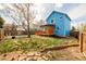 Backyard of a blue house with a deck, offering a mix of lawn and garden beds for outdoor enjoyment at 4922 S Rifle Ct, Aurora, CO 80015