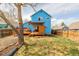 Backyard of a blue home with a cozy wooden deck and an expansive lawn space for outdoor activities at 4922 S Rifle Ct, Aurora, CO 80015