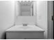A well-lit bathroom featuring a white vanity, large mirror, and a shower/tub combination with neutral tile at 4922 S Rifle Ct, Aurora, CO 80015