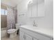 Bathroom with tub-shower with colorful patterned curtain, vanity, and medicine cabinet at 4922 S Rifle Ct, Aurora, CO 80015