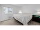 A bright bedroom with a large window, neutral walls and carpet, and minimal furniture at 4922 S Rifle Ct, Aurora, CO 80015