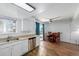 A kitchen with white cabinets and stainless steel dishwasher adjoins a dining area with table and a patio door at 4922 S Rifle Ct, Aurora, CO 80015