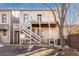 Rear exterior view of building featuring multiple access points, wooden stairs, and elevated wooden deck at 1310 N Corona St # A, Denver, CO 80218