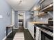 Efficient kitchen with light wood countertops, open shelving, stainless steel appliances, and access to bedroom at 1310 N Corona St # A, Denver, CO 80218