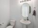 Clean bathroom with pedestal sink, toilet and oval mirror at 24281 E 40Th Ave, Aurora, CO 80019