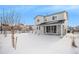 Two-story home with backyard, covered patio, and snowy landscape at 24281 E 40Th Ave, Aurora, CO 80019