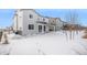 Two-story home with backyard, covered patio, and snowy landscape at 24281 E 40Th Ave, Aurora, CO 80019