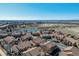 Scenic aerial shot of a neighborhood featuring tiled-roof homes, green spaces, and a tranquil pond at 4648 S Abilene Cir, Aurora, CO 80015