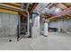 Unfinished basement with exposed ceiling, concrete walls and water tank at 4648 S Abilene Cir, Aurora, CO 80015