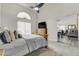 Bedroom showcases a ceiling fan, arched window, and a comfortable wooden bed, looking towards the living area at 4648 S Abilene Cir, Aurora, CO 80015